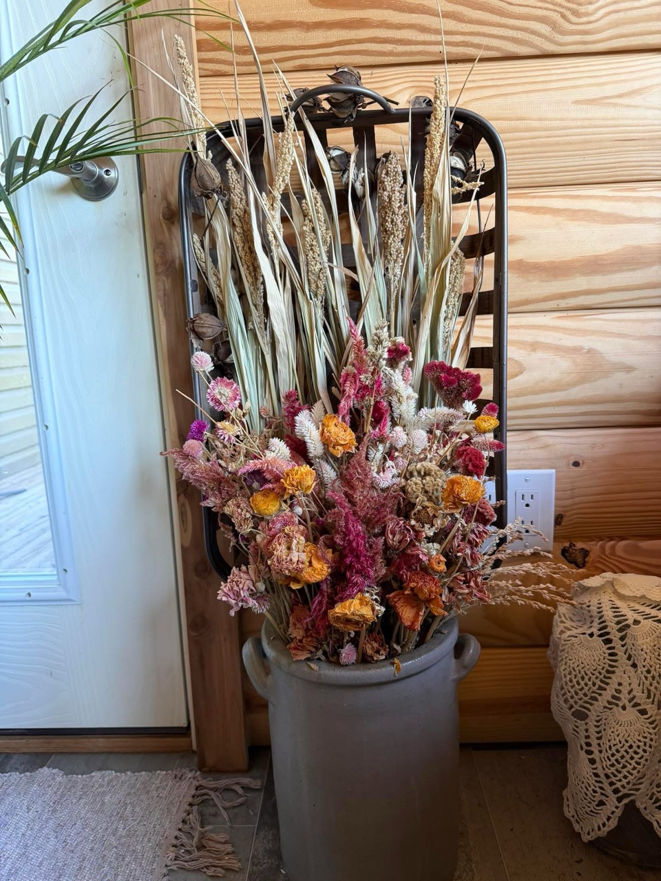 Dried flowers and grasses arranged in a gray crock